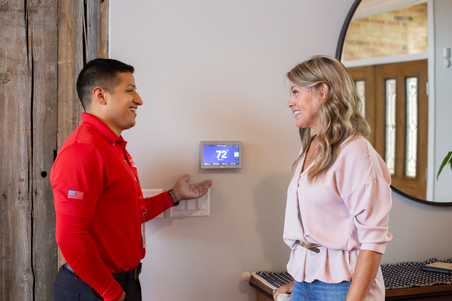 Perfect Home Services technician showing client new thermostat