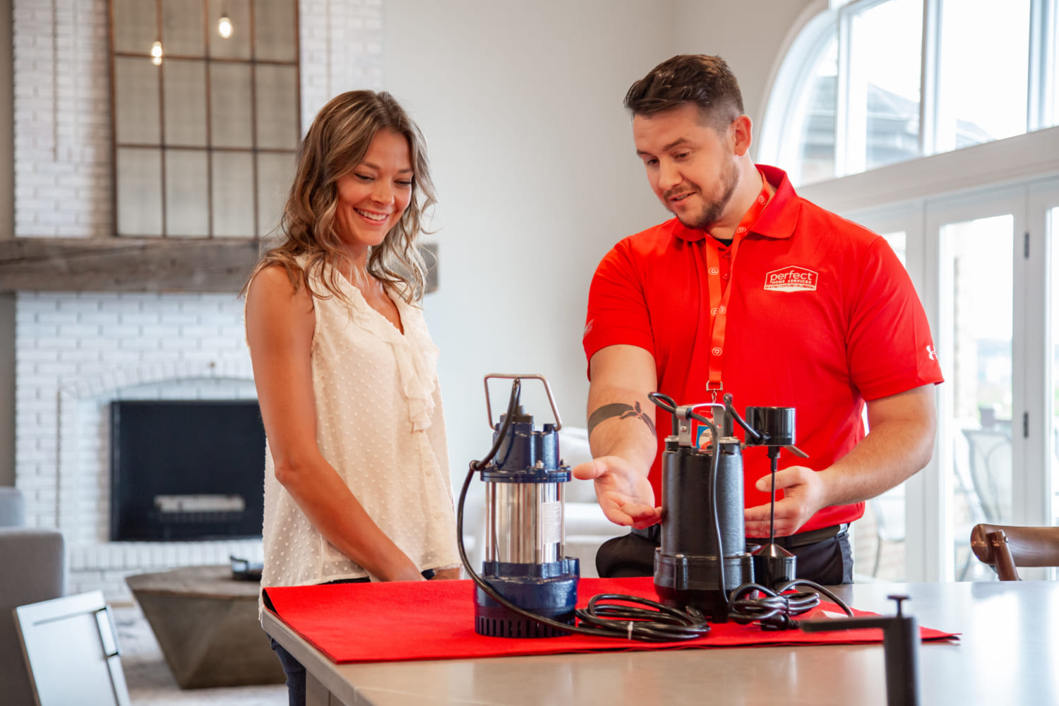 Perfect Home Services technician showing client different sump pumps