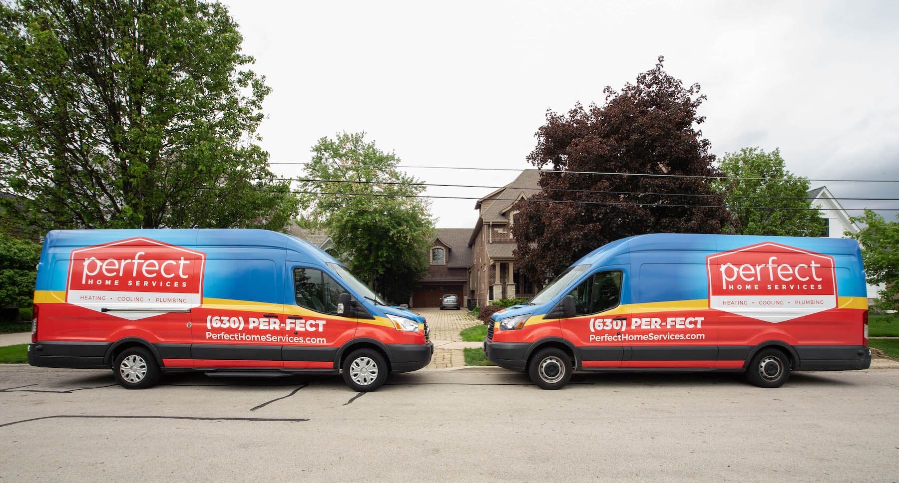 two Perfect Home Services trucks in front of residence